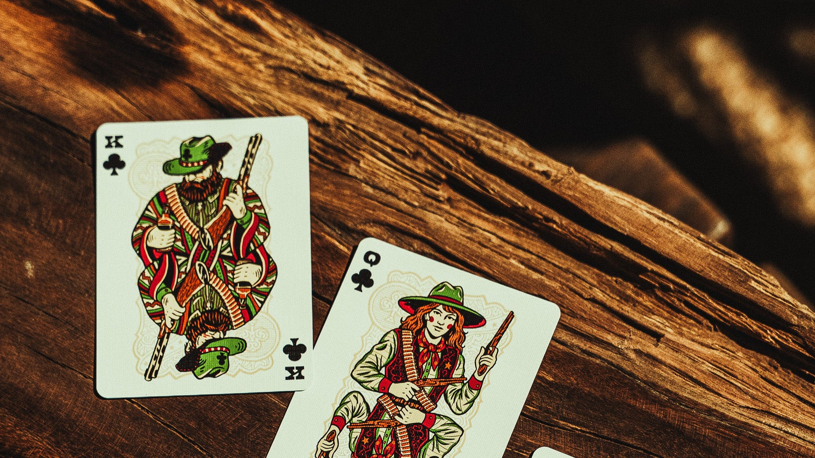 Three playing cards with a soldier design on a wooden surface